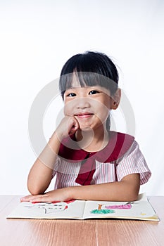 Asian Little Chinese girl reading a painting book