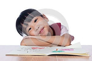 Asian Little Chinese girl reading a painting book