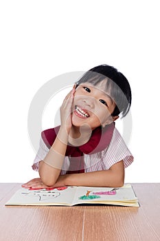 Asian Little Chinese girl reading a painting book