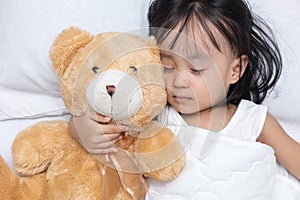 Asian little Chinese girl sleeping with teddy bear