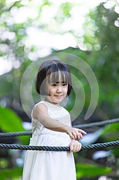 Asian Little Chinese Girl standing on a bridge