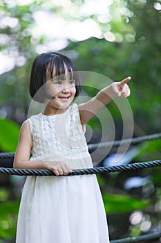 Asian Little Chinese Girl standing on a bridge