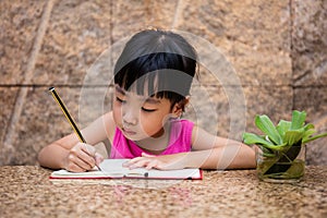 Asian little Chinese girl writing homework