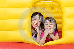 Asian Little Chinese sisters playing at inflatable castle