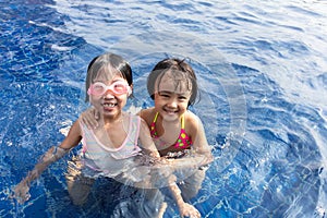 Asian Little Chinese Sisters Playing in Swimming Pool