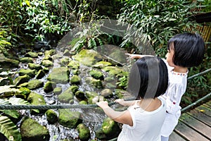 Asian Little Chinese Sisters standing on a wooden bridge