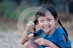 Asian little gilr  holding a chick in her hand with love and happy