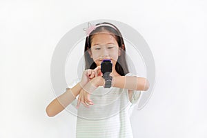 Asian little girl child using smart watch video camera against white background. Focus at smart watch at his hands