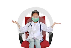 Asian little girl child in white doctor gown and protective mask with open arms wide sitting on red chair isolated on white studio