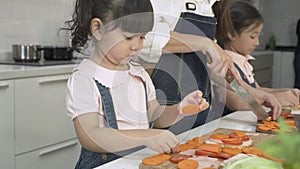 Asian little girl daughter and mother prepare dinner in the kitchen