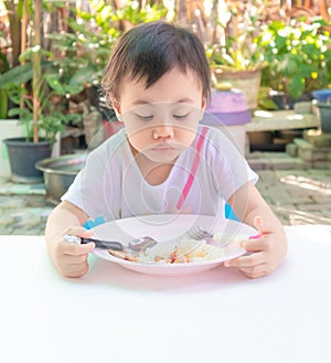 Asian little girl eating tasteless food for lunch, loss of appetite
