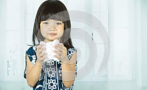 Asian little girl hand holding white piggy bank, learn to saving for the future concept