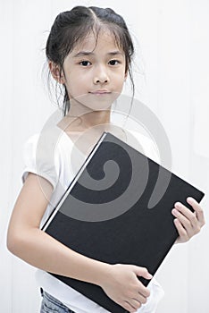 Asian little girl hold textbook.