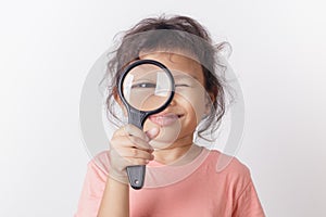 Asian little girl holding magnifying glass smiling. A Little cute child girl looking magnifying glass on white background