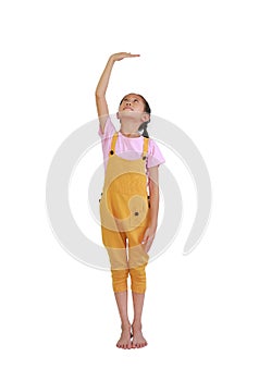 Asian little girl kid measures the growth isolated over white background. Child estimate her height by hand
