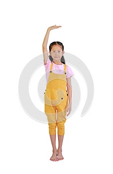 Asian little girl kid measures the growth isolated over white background. Child estimate her height by hand