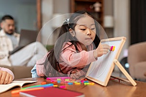 Asian Little Girl Learning Alphabet Playing With Magnetic Board Indoors