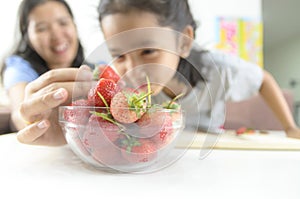 Asian little girl and mother picking straberry in glass bowl, Se