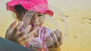 Asian little girl plaing sand on beach outdoor