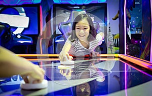 Asian little girl playing arcade game on the computer machines at the shopping mall outlets,holiday activities of cute child play