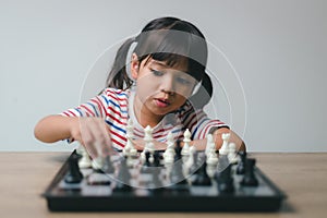 Asian little girl playing chess at home.a game of chess