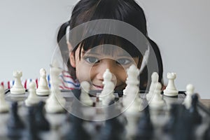 Asian little girl playing chess at home.a game of chess