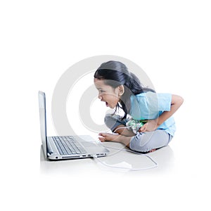 Asian little girl playing games with laptop computer and joystick controller isolated on white background