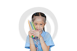 Asian little girl in school uniform holding color pencils over white background. Education and school concept