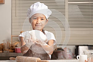An Asian little girl showing make the dough for a homemade bakery