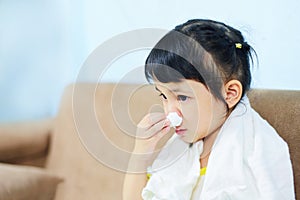 Asian little girl sick wrapped in handkerchief get cold and blow nose the flu season child runny nose and sneezing blowing their