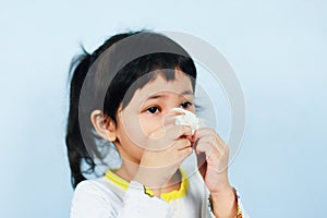 Asian little girl sick wrapped in handkerchief get cold and blow nose the flu season - child runny nose and sneezing blowing their