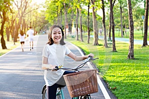 Asian little girl is smiling and looking at the camera on the bike in outdoor park,portrait of happy cute child with bicycle,