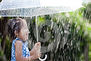 Asian little girl with umbrella in rain