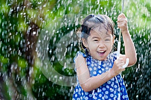 Asian little girl with umbrella in rain