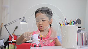 Asian little girl using the color pencil sharpener