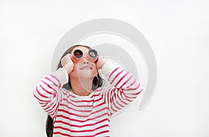 Asian little girl wearing a telescope glasses and looking up over white background isolated. Kid and adventure concept