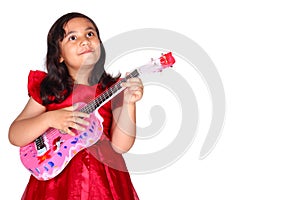 Asian little girl on white background isolated (6 year old) was playing the ukulele