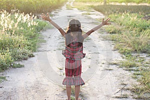 Asian little girl wore a dress made of Thai loincloth or Kamar band or Commer band standing with arms raise her back.