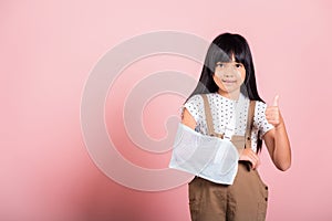 Asian little kid 10 years old hand bone broken from accident with arm splint show thumb up finger