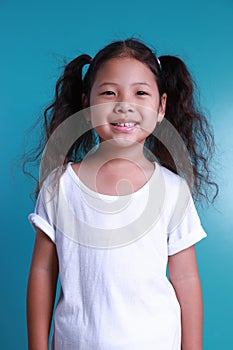 Asian little kid girl smile happiness portrait looking at the camera on green background