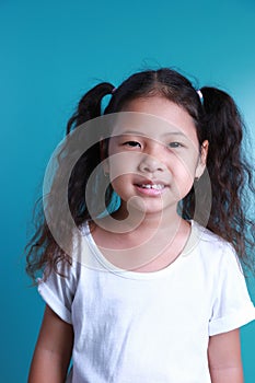 Asian little kid girl smile happiness portrait looking at the camera on green background