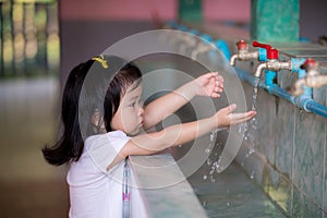 Asian little kid girl washing her hands.