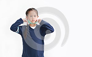 Asian little kid girl wearing medical face mask slung on her chin isolated on white background. Amid covid-19 pandemic concept