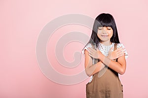 Asian little kid 10 years old doing grateful gesture and closed eyes