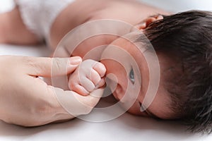 Asian Little newborn baby girl one month old. infant. hand the practicing development baby in the hand of mother close up, New