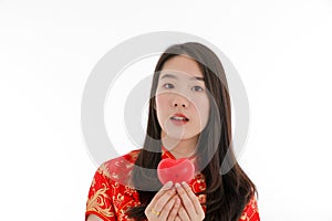 The asian little pretty girl wearing chinese traditional dress and holding the red heart