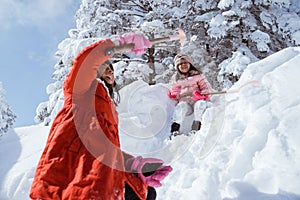 asian little sister playing in snowy winter together