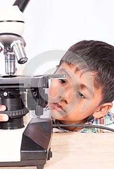 Asian little student boy working with microscope