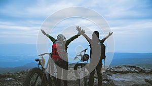 Asian lover women and men Travel Nature. Travel relax ride a bike Wilderness in the wild. Standing on a rocky cliff. travel