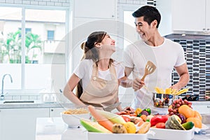 Asian lovers or couples cooking so funny together in kitchen wit